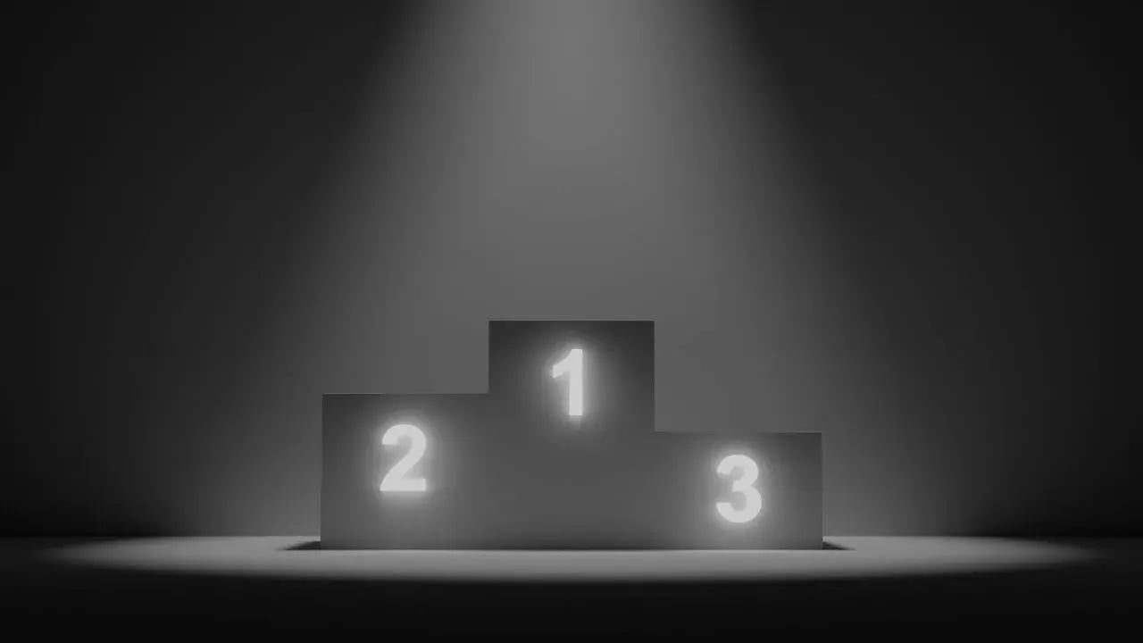 A podium with three levels, illuminated by a spotlight