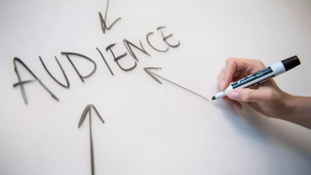 a hand holding a marker, writing the word 