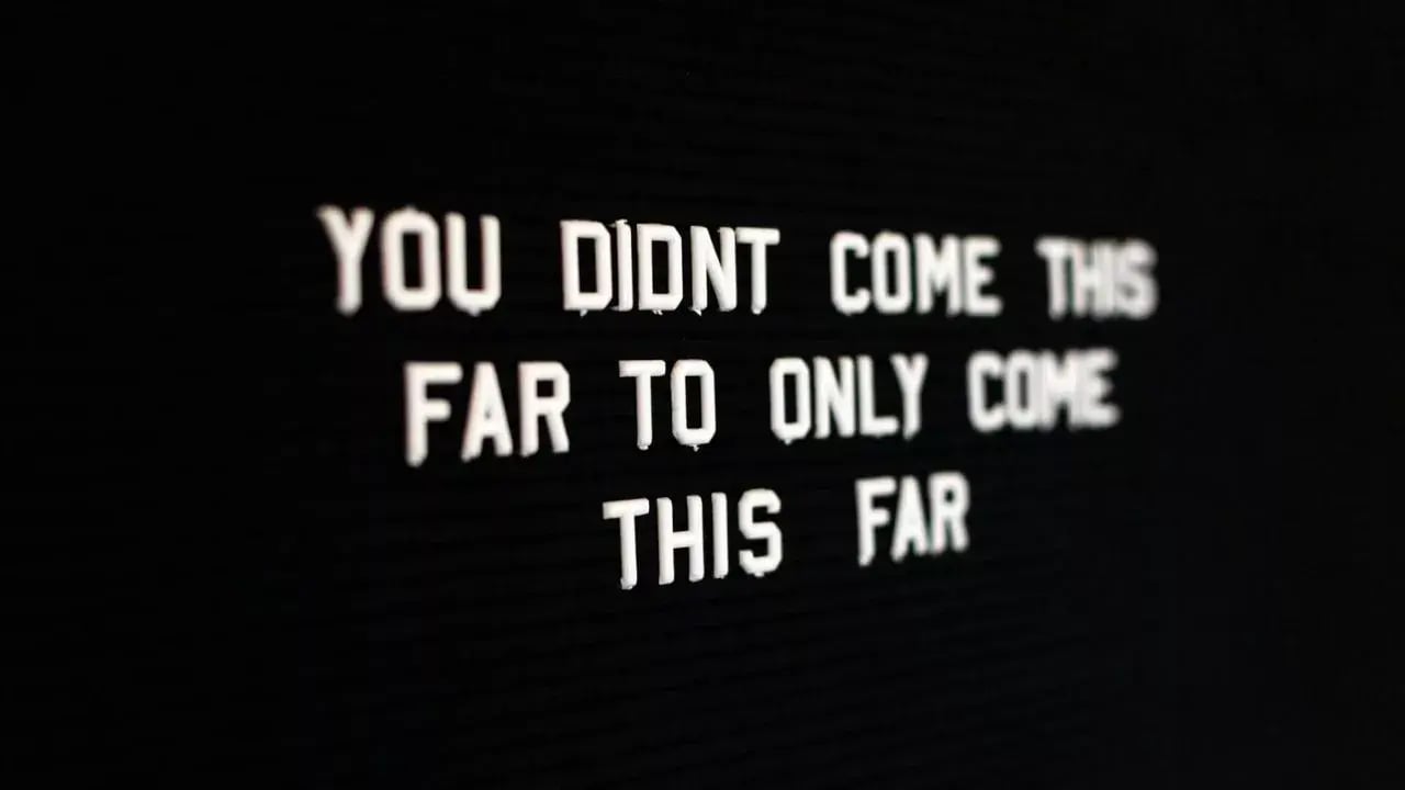 A motivational quote displayed in bold white letters on a black background: 