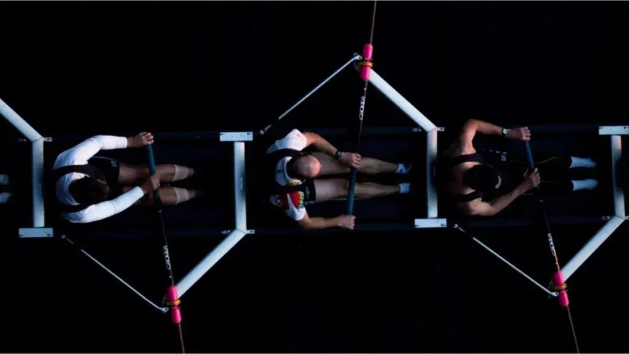 Three individuals are engaged in a climbing activity