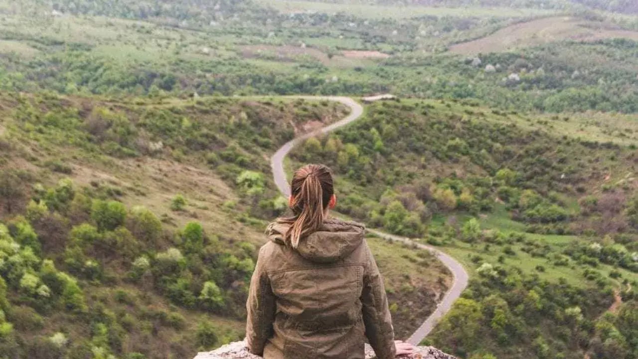 A person sitting on a rocky ledge